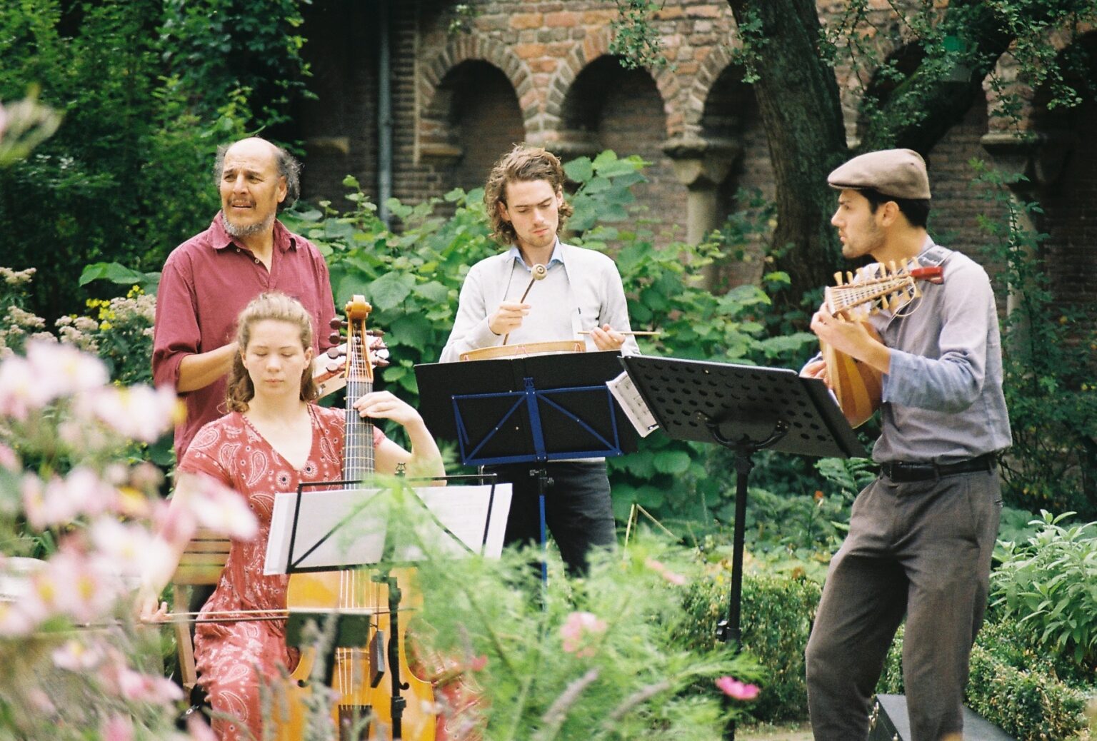 Musicians with viol, lute and drum in a cloister garden